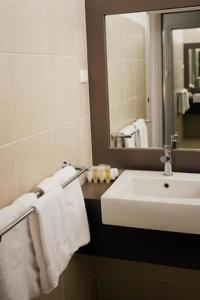 uma casa de banho com um lavatório branco e um espelho. em Southgate em Shepparton