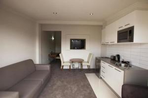 a kitchen and living room with a couch and a table at Southgate in Shepparton