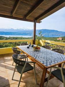 a table and chairs on a patio with a view at Villa Aitheras with sea views and garden in Stérnai