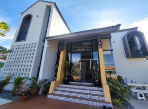 a white building with a sign on the front of it at อยู่สบายวิลล่า ยโสธร in Yasothon