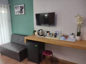 a living room with a counter with a couch and a table at อยู่สบายวิลล่า ยโสธร in Yasothon