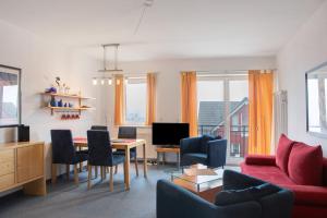 a living room with a red couch and a table at Ferienwohnung Tannenblick 2-4 in Oberhof