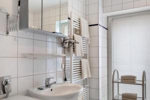 a white bathroom with a sink and a mirror at Ferienwohnung Tannenblick 2-4 in Oberhof +25 photos