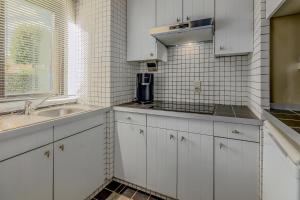 a kitchen with white cabinets and a sink and a window at Rietpanne Gv06 in Sint-Idesbald +12 photos