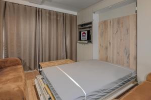 a small bedroom with a bed and a couch at Rietpanne Gv06 in Sint-Idesbald