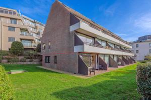 an exterior view of a brick building with a lawn at Rietpanne Gv06 in Sint-Idesbald