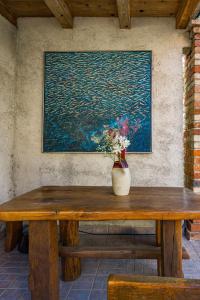 un tavolo di legno con un vaso di fiori sopra di Apartments Blanka - Garden Oasis with Jacuzzi a Banjol Altre 8 foto