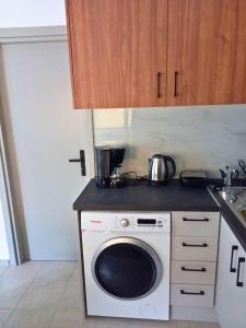 a kitchen with a washing machine on a counter at KaVros Cozy Apartment in Kavros +49 photos