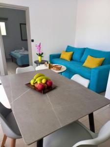 a table with a plate of fruit on it in a living room at KaVros Cozy Apartment in Kavros
