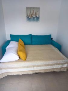 a bed with a blue headboard and two yellow pillows at KaVros Cozy Apartment in Kavros