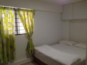 a small bedroom with a bed and a window at Axis Hotel in Taiping