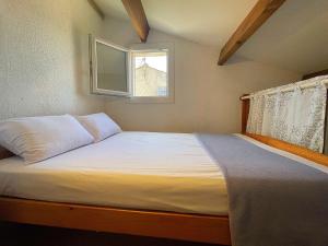 ViresにあるMaison studio mezzanine - Gruissan AY010-005の窓のある小さな部屋のベッド