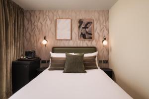 a bedroom with a large white bed with two lamps at Central Park Hotel in London +54 photos