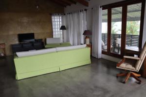 a living room with a green couch and a chair at Mount Bliss Home Stay in Mount Lavinia