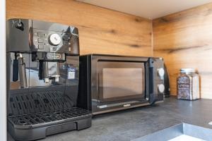a coffee maker and a microwave on a counter at TAMLiving Countryside 2BR Küche in Ottendorf bei Gleisdorf