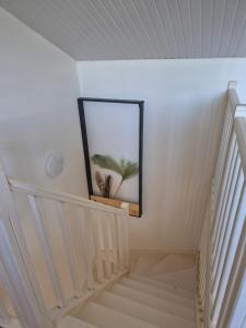 a staircase with a mirror and a picture on the wall at Maison charmante à Sainte-Anne avec jardin et pergola en bois. in Sainte-Anne