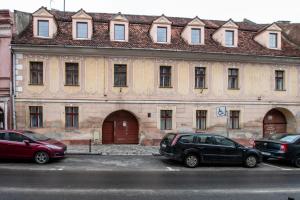 two cars parked in a parking lot in front of a building at Altius Studio in Braşov