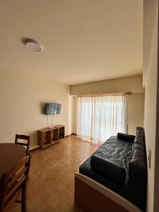 a bedroom with a black bed and a television at Departamento "La Casita" con Vista al Mar in San Clemente del Tuyú