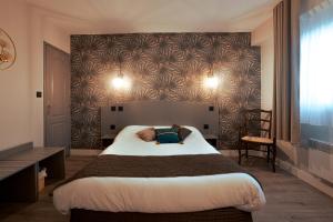 a bedroom with a large bed with a wall at Logis Hôtel - Auberge du Pastel - Hôtel 3 étoiles et Restaurant in Nailloux +73 photos