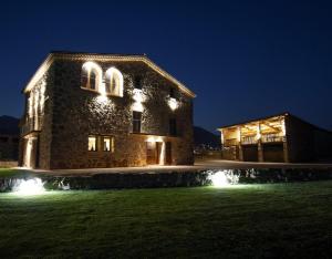 a large stone building with lights on it at night at La Creu De La Pinya in Berga