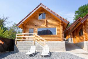 a log cabin with two chairs in front of it at Long Rock Chalets in Rimetea