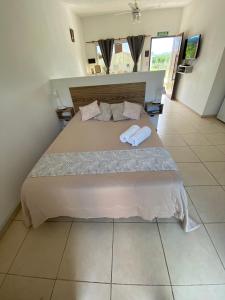 a bedroom with a large bed with two towels on it at AROMA DEL POTRERO in Potrero de los Funes