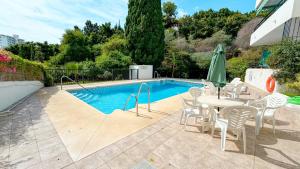 a patio with a table and chairs next to a pool at Bahamas in Nerja