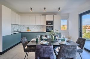 a kitchen and dining room with a table and chairs at The Lookout Liveli - Premium Sea-View Apartment in Slatine