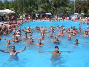 eine große Gruppe von Personen, die in einem Schwimmbad schwimmen in der Unterkunft Kamemi Village & Camping in Ribera