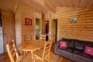 阿戈斯维达洛斯Camping écovillage Soleil du Pibeste的小屋内带桌子和沙发的用餐室 更多37张照片