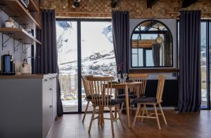 a kitchen with a table and chairs and a large window at Cottage River Sound in Kazbegi