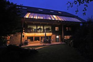 a large brick house with people sitting in front of it at Haldenhof, Design Retreat im Schwarzwald by living TIMELESS in Simonswald