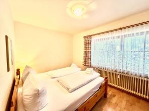 ein kleines Schlafzimmer mit einem Bett und einem Fenster in der Unterkunft Appartementhaus Königstraße Ferienwohnung Linderhof in Füssen