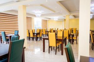 a dining room with tables and yellow chairs at Viveka Hotel Colombo in Colombo