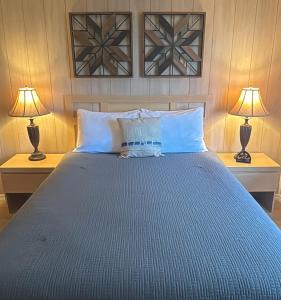 a bedroom with a blue bed with two lamps at River Wilderness Waterfront Cabins in Everglades City