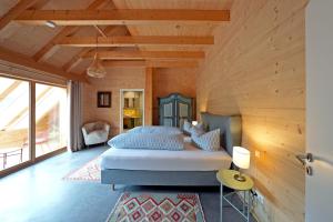 a bedroom with a bed in a room with wooden walls at Haldenhof, Design Retreat im Schwarzwald by living TIMELESS in Simonswald