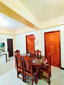 a dining room with a wooden table and chairs at The Key Transient in La Trinidad