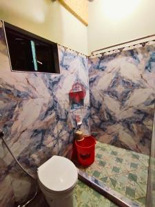 a bathroom with a toilet and a marble wall at The Key Transient in La Trinidad
