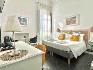a bedroom with a bed with yellow pillows on it at Hotel Posta in Syracuse