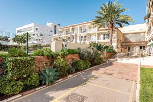 een straat voor een gebouw met een palmboom bij Beach Palace Carihuela in Torremolinos