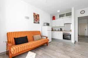 een woonkamer met een bank en een keuken bij Beach Palace Carihuela in Torremolinos