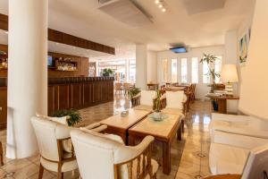 a restaurant with tables and chairs and a bar at Hotel Alhambra in Punta del Este
