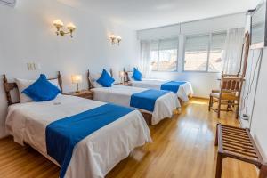 two beds in a room with blue and white at Hotel Alhambra in Punta del Este