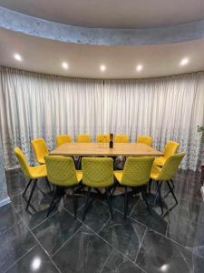 a conference room with a wooden table and yellow chairs at Къща за гости Гардения in Kamburovo +80 photos
