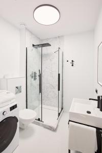 a bathroom with a shower and a toilet and a sink at Apartament Husarski - City Park in Poznań +66 photos