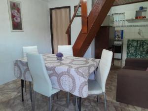 una sala da pranzo con un tavolo e sedie bianche di Puerto del sol a Punta Del Diablo