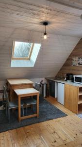 a room with a table and a kitchen in a cabin at Les Roses Des Bois in Murat-le-Quaire