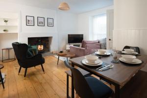 a living room with a table and chairs and a fireplace at T&J House in Eyemouth: Cozy Coastal Retreat in Eyemouth