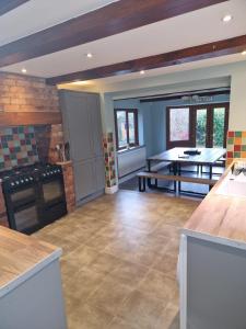 a large kitchen with a table and a dining room at Hereford - Falcon House - Spacious 5 Bedroom House With Games Room - Sleeps 14 Guests - Great Property For Family & Friends Gathering Together - Hosted by RENTMYHOUSE in Hereford