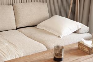 Sofá blanco con almohada en el suelo de madera en 1BHK Poolview Apartment With Balcony - Timber Retreat, en Sharjah